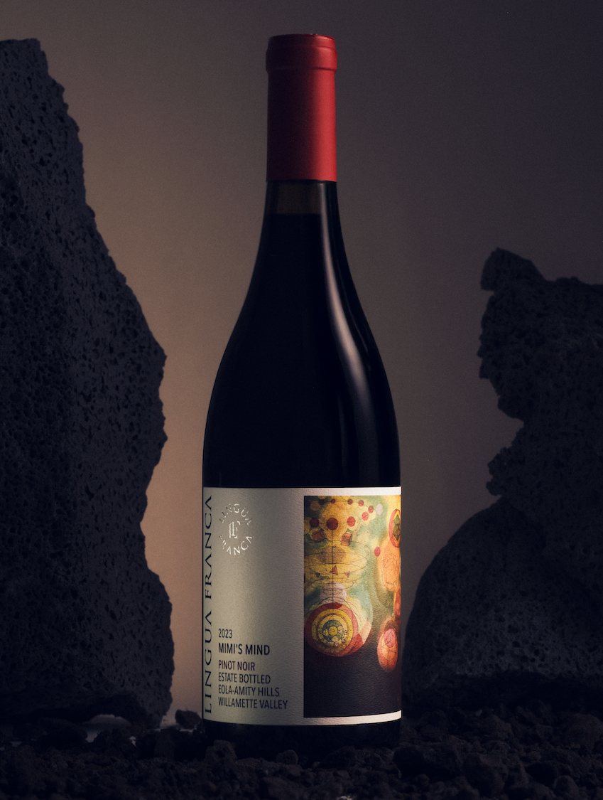 A bottle of 2023 Mimi's Mind Pinot Noir against dark rocks